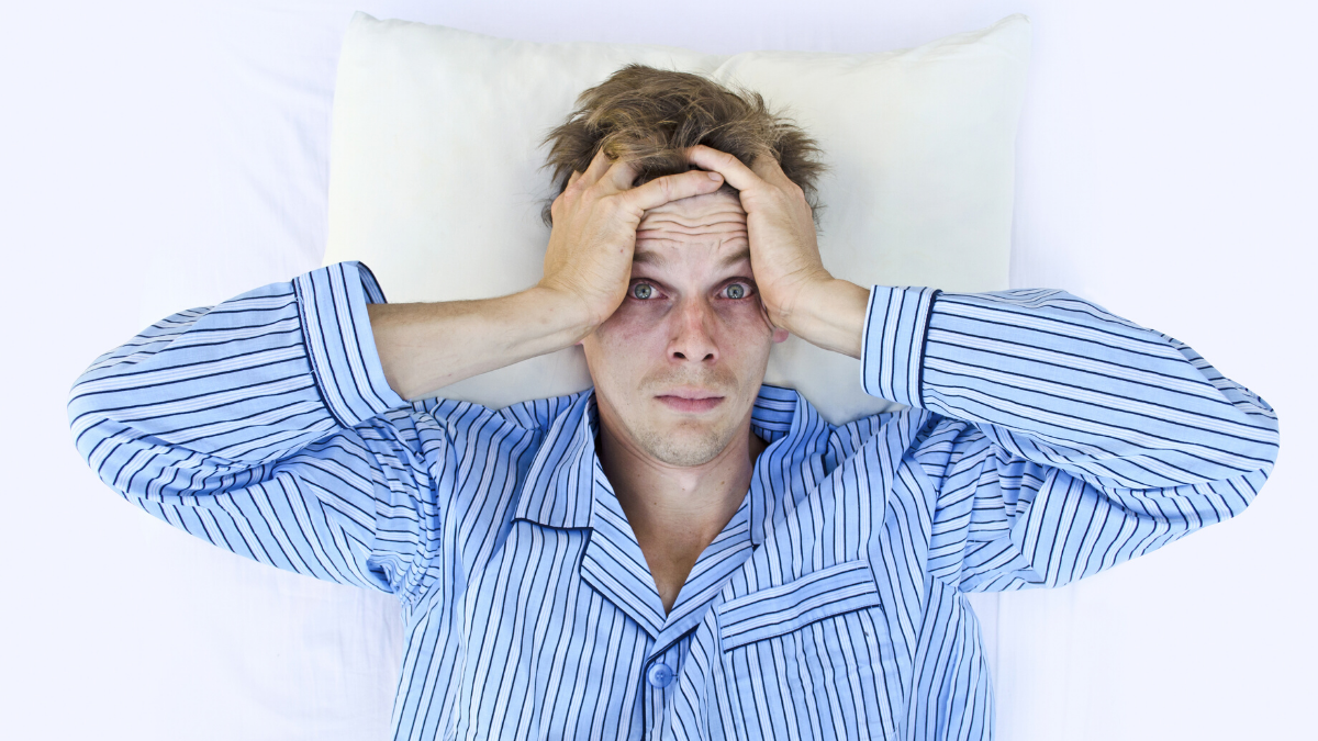 man lying awake trying to sleep